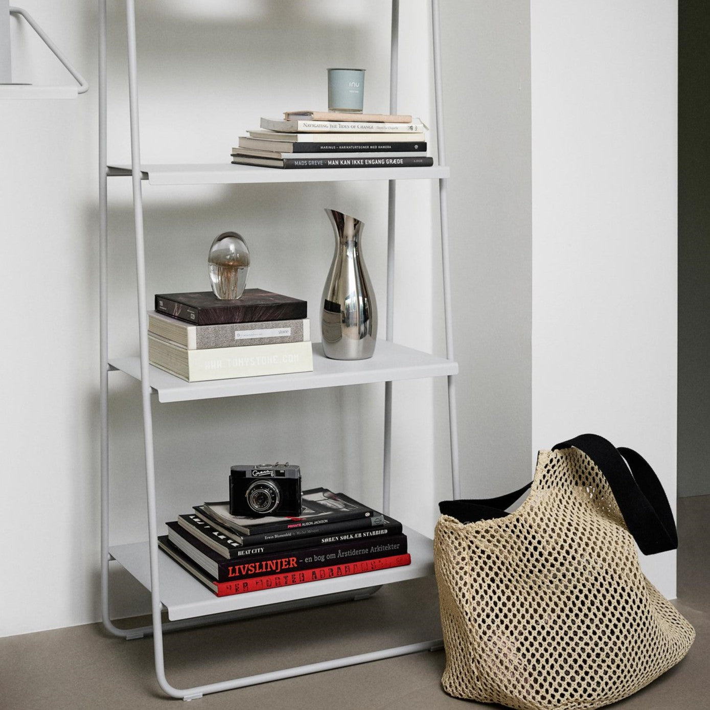White bookshelf with books and decorative items against a white wall.