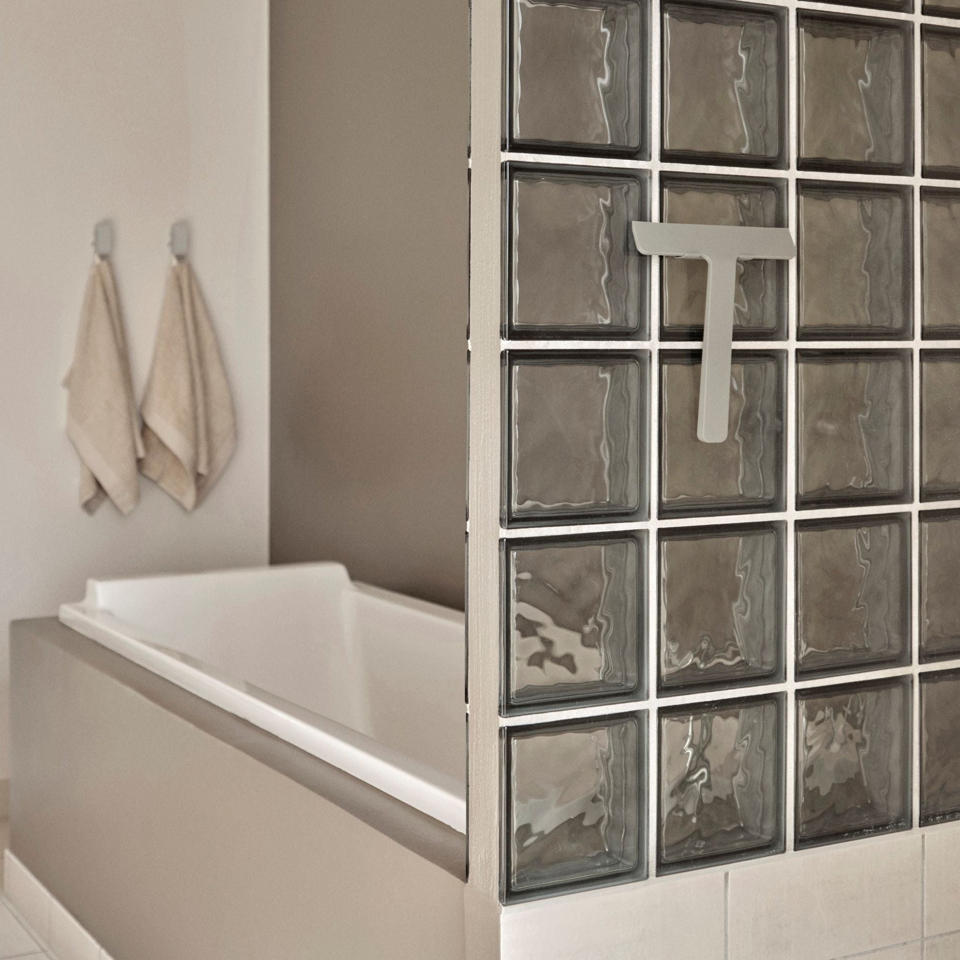 Bathroom with a bathtub and glass block wall